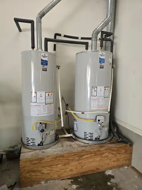Twin tank water heaters side by side on a platform