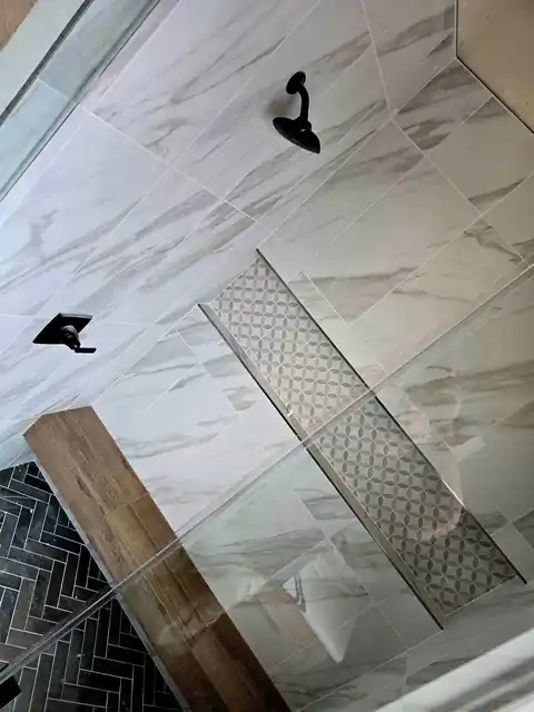 Linear shower drain set in marble-look tile