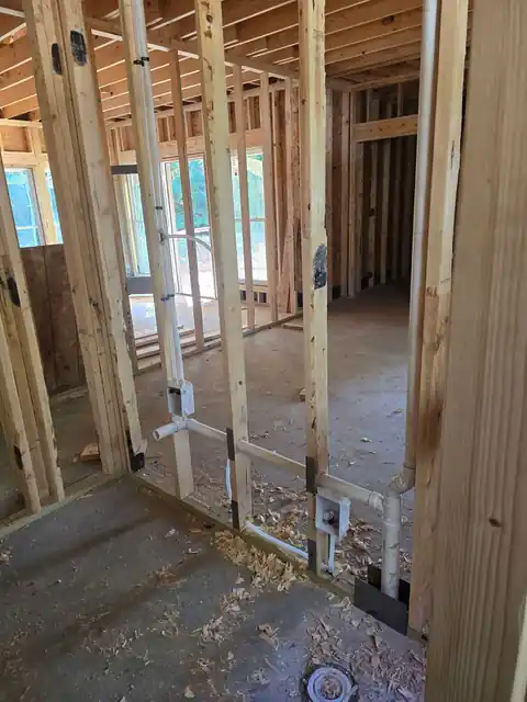 Supply and drain rough-in run through new wall framing