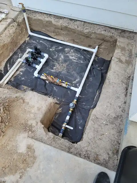 Under-slab drain rough-in exposed in a cut concrete slab